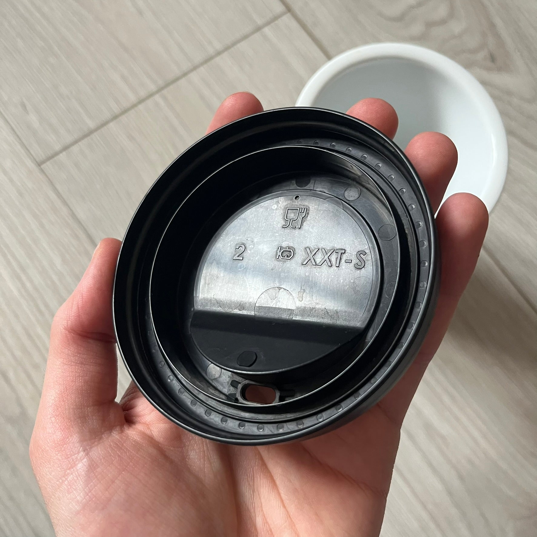 Balenciaga Dallas Black Coffee Cup crafted from glossy black porcelain with a white interior. Features a bold white Balenciaga logo with “Dallas” text underneath and a matching black rubber lid. A refined collectible showcasing everyday luxury.&nbsp;