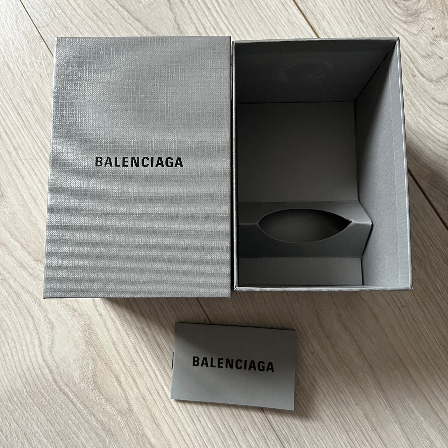 Balenciaga Dallas Black Coffee Cup crafted from glossy black porcelain with a white interior. Features a bold white Balenciaga logo with “Dallas” text underneath and a matching black rubber lid. A refined collectible showcasing everyday luxury.&nbsp;