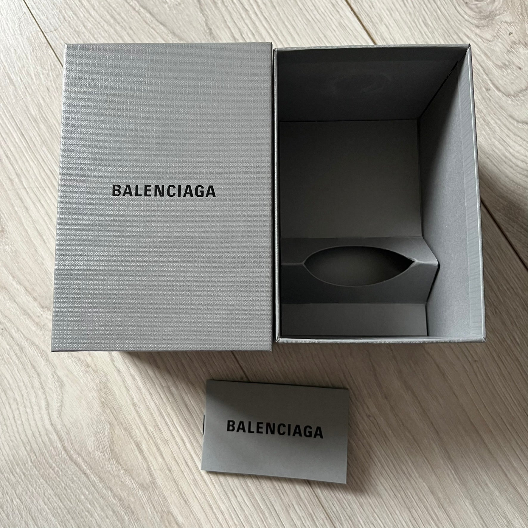 Balenciaga Dallas Black Coffee Cup crafted from glossy black porcelain with a white interior. Features a bold white Balenciaga logo with “Dallas” text underneath and a matching black rubber lid. A refined collectible showcasing everyday luxury.&nbsp;