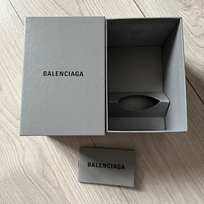 Balenciaga Dallas Black Coffee Cup crafted from glossy black porcelain with a white interior. Features a bold white Balenciaga logo with “Dallas” text underneath and a matching black rubber lid. A refined collectible showcasing everyday luxury.&nbsp;