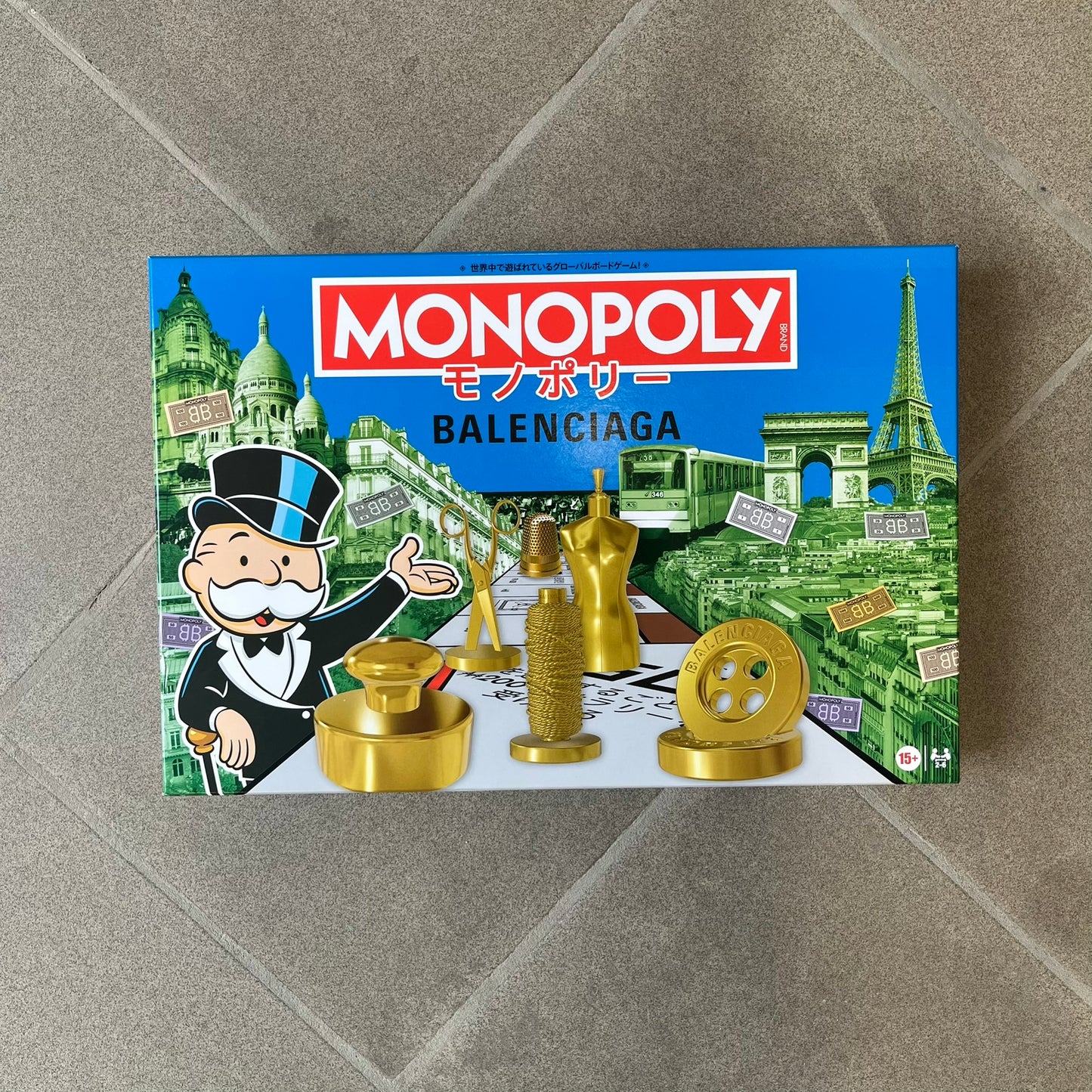 Balenciaga Monopoly 2025 VIP Gift Board Game features a custom Monopoly design made for Balenciaga. The game includes gold-tone fashion-themed playing pieces such as scissors, a thimble, thread spool, and mannequin. The board replaces standard properties with Balenciaga stores and locations, while the currency and cards feature Balenciaga branding and custom references including “Balenciaga Tax.”
