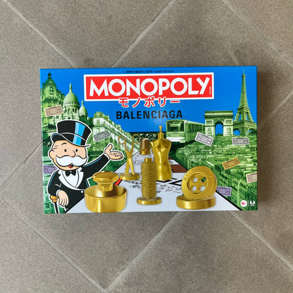 Balenciaga Monopoly 2025 VIP Gift Board Game features a custom Monopoly design made for Balenciaga. The game includes gold-tone fashion-themed playing pieces such as scissors, a thimble, thread spool, and mannequin. The board replaces standard properties with Balenciaga stores and locations, while the currency and cards feature Balenciaga branding and custom references including “Balenciaga Tax.”

