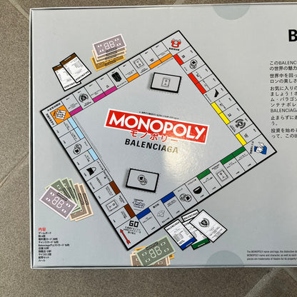 Balenciaga Monopoly 2025 VIP Gift Board Game features a custom Monopoly design made for Balenciaga. The game includes gold-tone fashion-themed playing pieces such as scissors, a thimble, thread spool, and mannequin. The board replaces standard properties with Balenciaga stores and locations, while the currency and cards feature Balenciaga branding and custom references including “Balenciaga Tax.”
