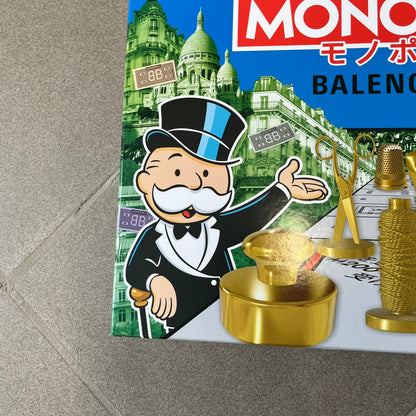 Balenciaga Monopoly 2025 VIP Gift Board Game features a custom Monopoly design made for Balenciaga. The game includes gold-tone fashion-themed playing pieces such as scissors, a thimble, thread spool, and mannequin. The board replaces standard properties with Balenciaga stores and locations, while the currency and cards feature Balenciaga branding and custom references including “Balenciaga Tax.”
