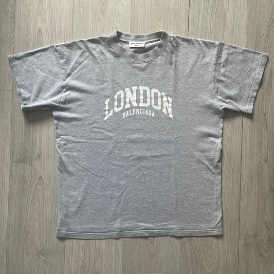 Gray t-shirt with 'London Balenciaga' text on a wooden surface