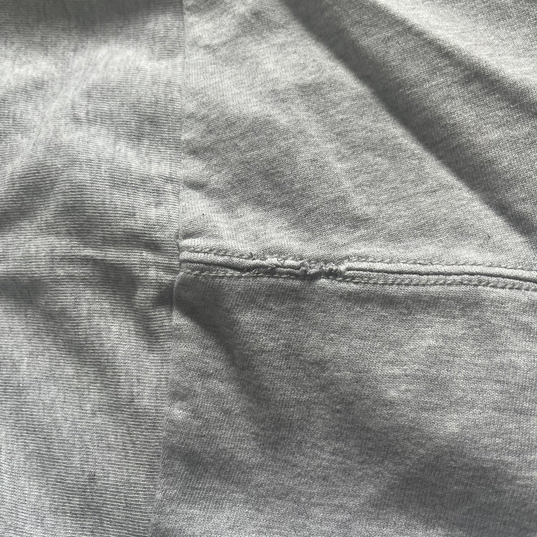 Close-up of gray fabric with a focus on texture and stitching.