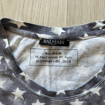 Balmain SS18 t-shirt in 100% cotton featuring a bold full-print USA flag on both sides. The front is accented with “Balmain Paris” text at the stomach, combining patriotic imagery with the brand’s signature luxury touch. A rare and powerful piece from the 2018 runway season.