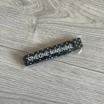Bazo 1199 “Black on White” Stars Bracelet is a acetate bead bracelet featuring black beads with white star graphics printed on the tops and sides. One bead is marked with a red 1199 logo on the inside. It comes with the original foil packaging.
