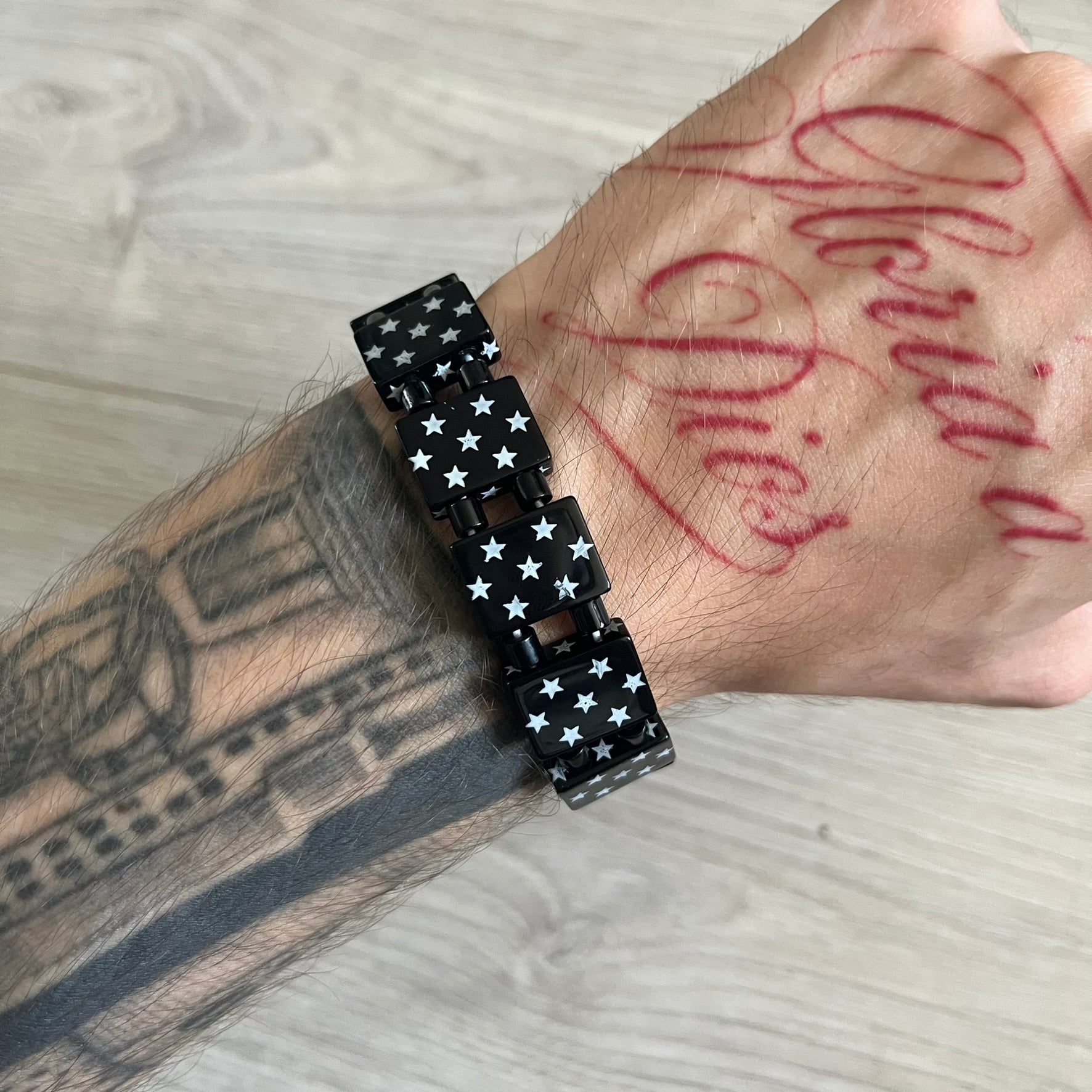 Bazo 1199 “Black on White” Stars Bracelet is a acetate bead bracelet featuring black beads with white star graphics printed on the tops and sides. One bead is marked with a red 1199 logo on the inside. It comes with the original foil packaging.
