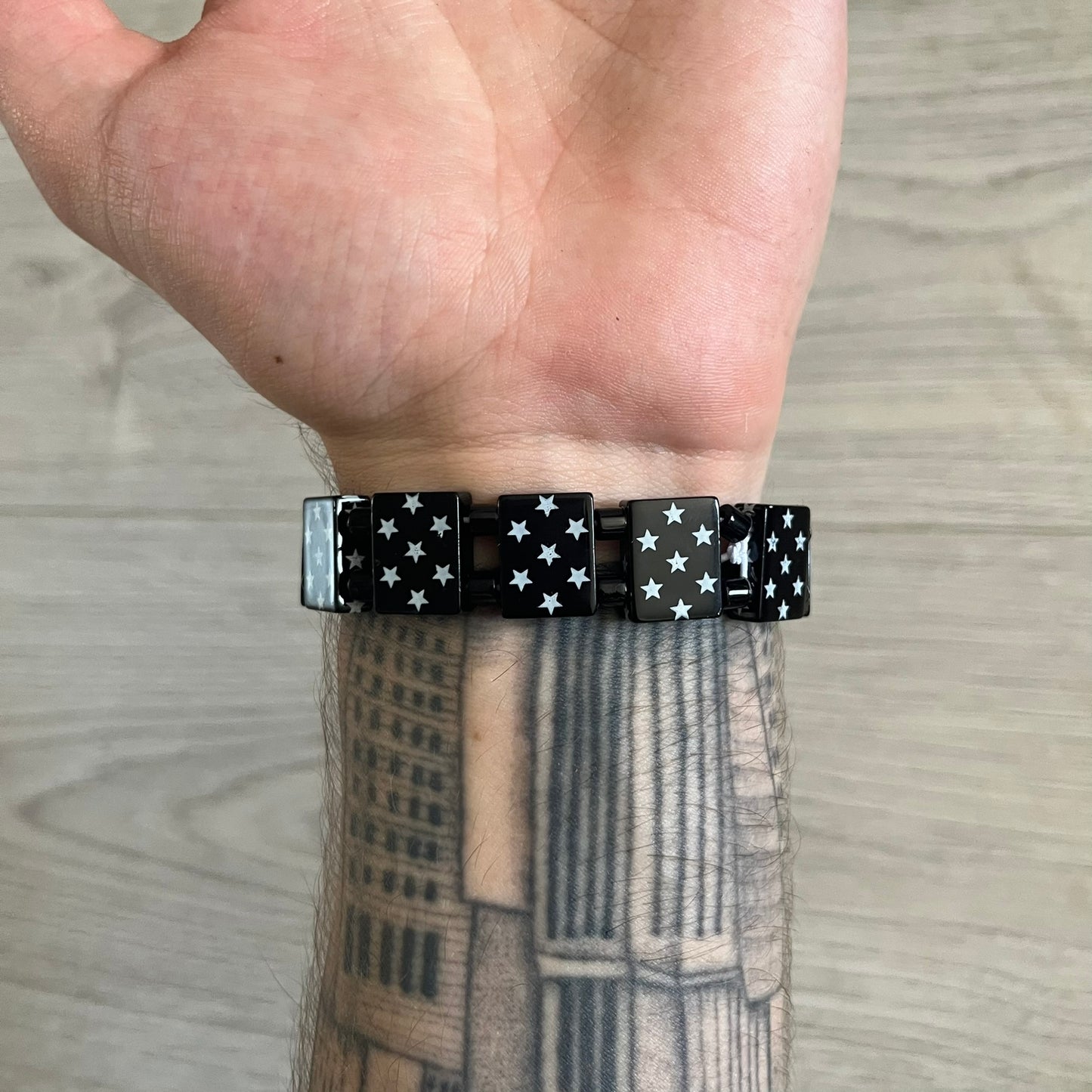 Bazo 1199 “Black on White” Stars Bracelet is a acetate bead bracelet featuring black beads with white star graphics printed on the tops and sides. One bead is marked with a red 1199 logo on the inside. It comes with the original foil packaging.

