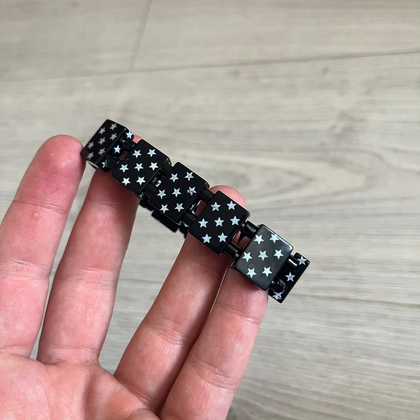 Bazo 1199 “Black on White” Stars Bracelet is a acetate bead bracelet featuring black beads with white star graphics printed on the tops and sides. One bead is marked with a red 1199 logo on the inside. It comes with the original foil packaging.
