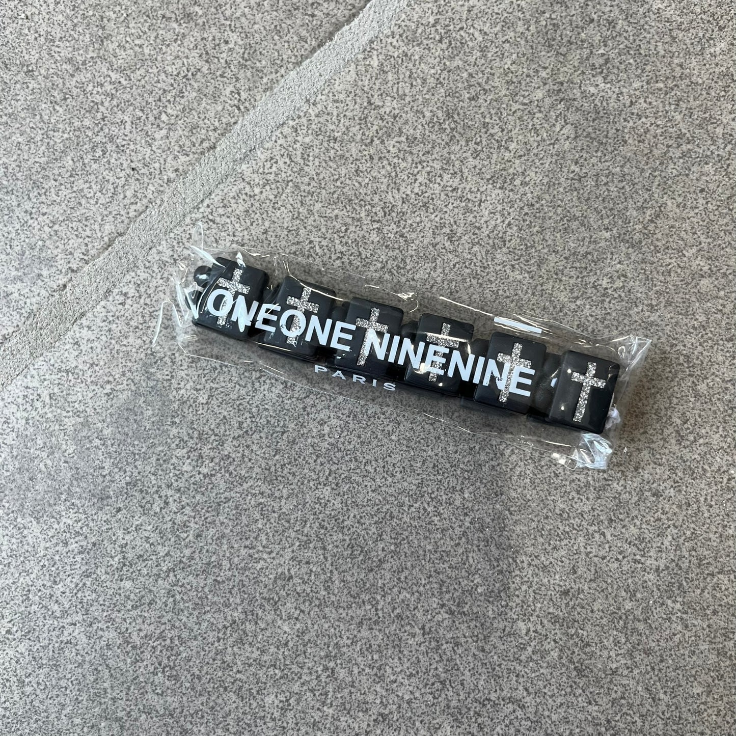 Bazo 1199 “God’s Lonely Kids” Bracelet is a black silicone bead bracelet featuring crystal cross details on the outside of each bead. The interior is engraved with the 1199 logo and “God’s Lonely Kids” text.