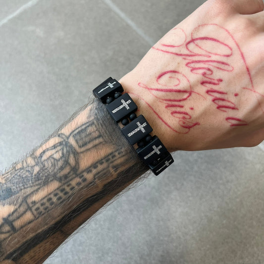 Bazo 1199 “God’s Lonely Kids” Bracelet is a black silicone bead bracelet featuring crystal cross details on the outside of each bead. The interior is engraved with the 1199 logo and “God’s Lonely Kids” text.&nbsp;&nbsp;