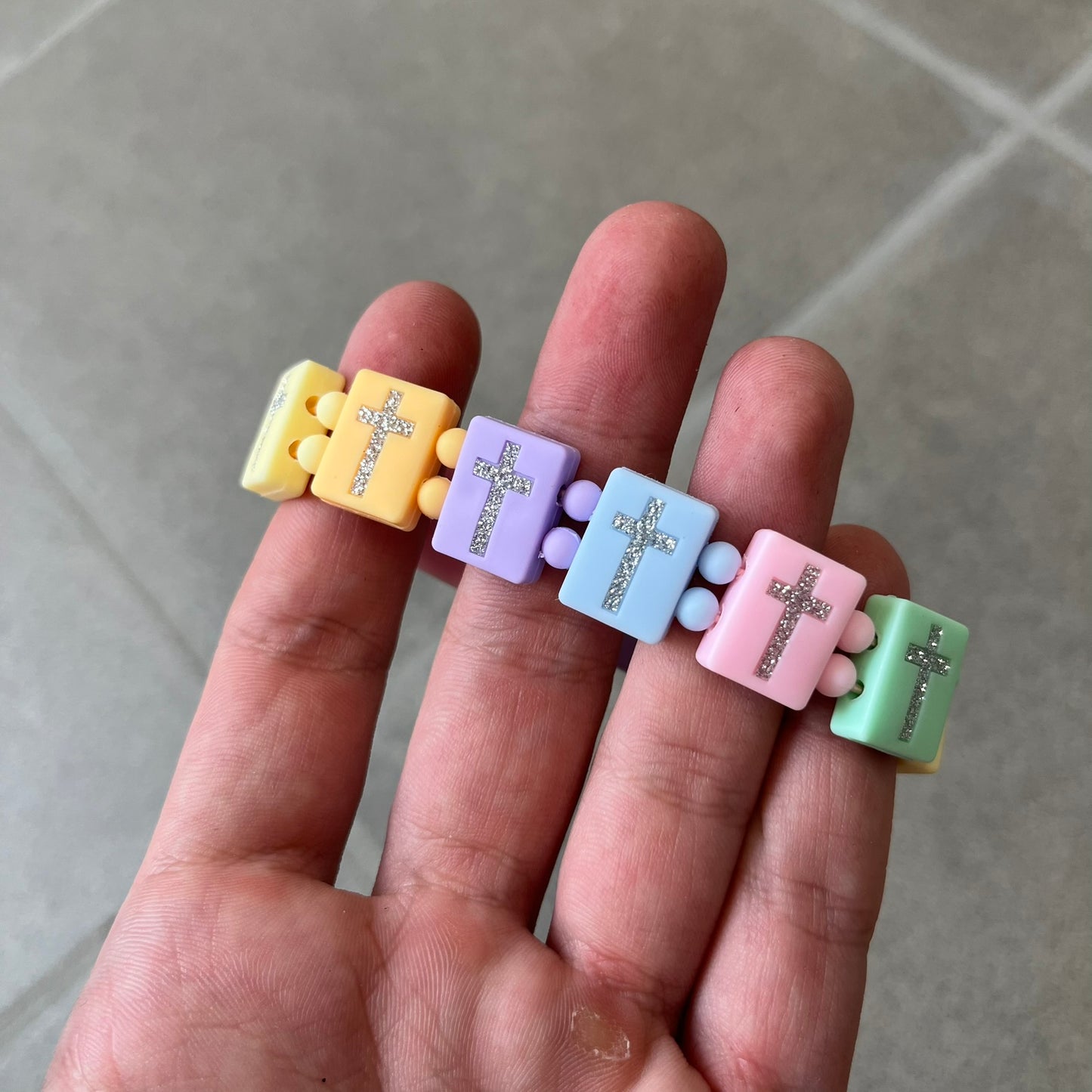 Bazo 1199 “God’s Lonely Kids” Bracelet is a multicolor silicone bead bracelet featuring crystal cross details on the outside of each bead. The interior is engraved with the 1199 logo and “God’s Lonely Kids” text.&nbsp;