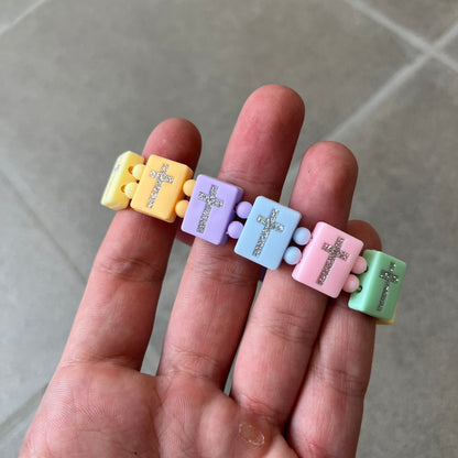 Bazo 1199 “God’s Lonely Kids” Bracelet is a multicolor silicone bead bracelet featuring crystal cross details on the outside of each bead. The interior is engraved with the 1199 logo and “God’s Lonely Kids” text.&nbsp;
