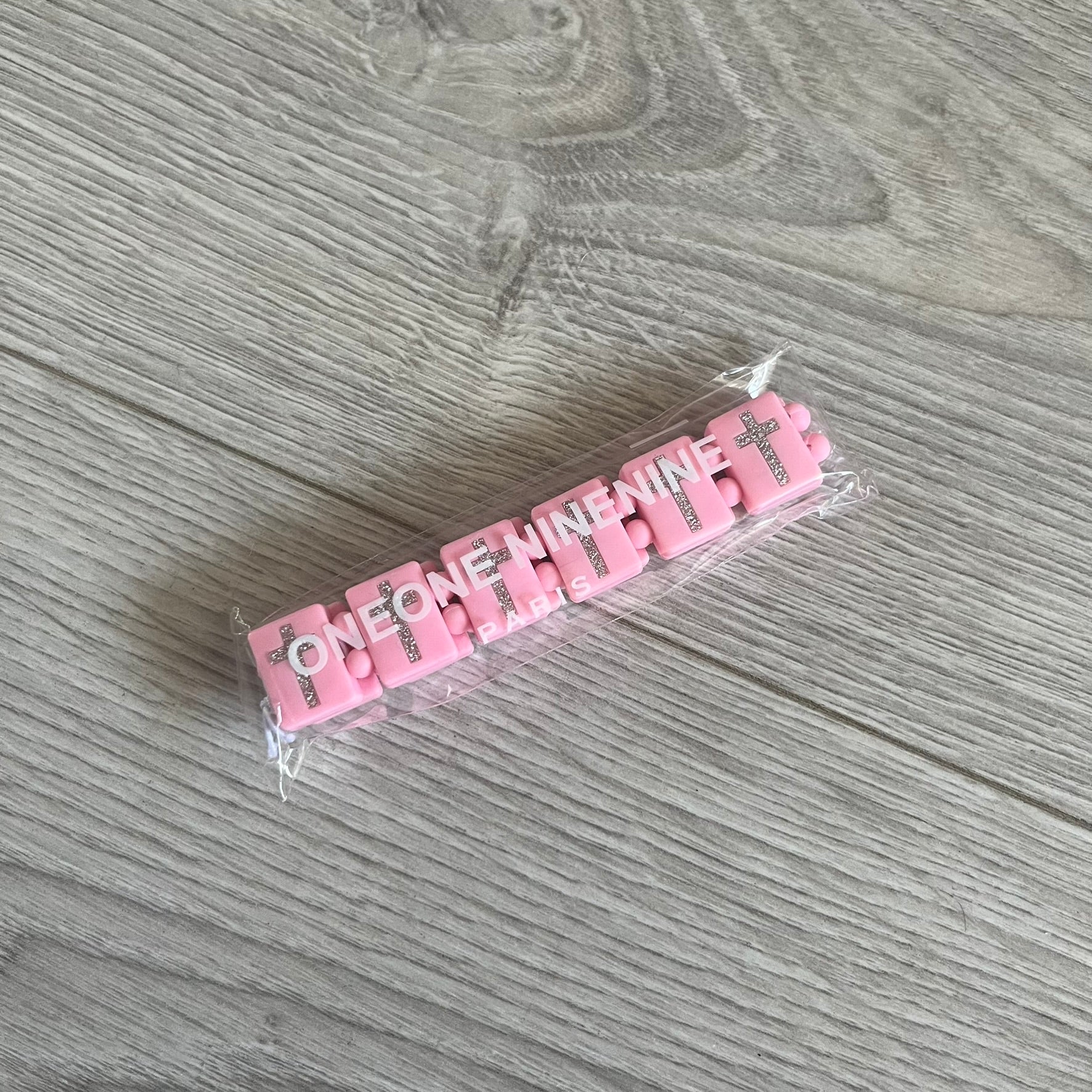 Bazo 1199 “God’s Lonely Kids” Bracelet is a pink silicone bead bracelet featuring crystal cross details on the outside of each bead. The interior is engraved with the 1199 logo and “God’s Lonely Kids” text. Comes with a plastic bag.&nbsp;