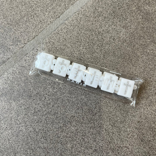 Bazo 1199 “God’s Lonely Kids” Bracelet is a white silicone bead bracelet featuring crystal cross details on the outside of each bead. The interior is engraved with the 1199 logo and “God’s Lonely Kids” text.