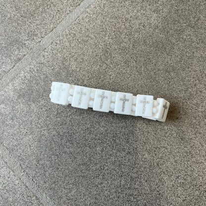 Bazo 1199 “God’s Lonely Kids” Bracelet is a white silicone bead bracelet featuring crystal cross details on the outside of each bead. The interior is engraved with the 1199 logo and “God’s Lonely Kids” text.