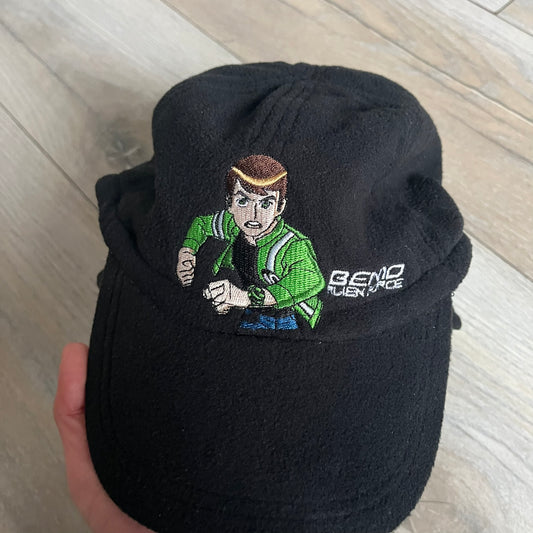 Ben 10 Alien Force Earflap 2011 Hat is a black polyester kids-size hat with green interior lining and earflaps on both sides. The front features embroidered Ben 10 character graphics with “Ben 10 Alien Force” text. Finished with an official 2011 Cartoon Network tag and a soft overall construction.