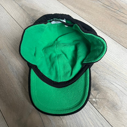 Ben 10 Alien Force Earflap 2011 Hat is a black polyester kids-size hat with green interior lining and earflaps on both sides. The front features embroidered Ben 10 character graphics with “Ben 10 Alien Force” text. Finished with an official 2011 Cartoon Network tag and a soft overall construction.
