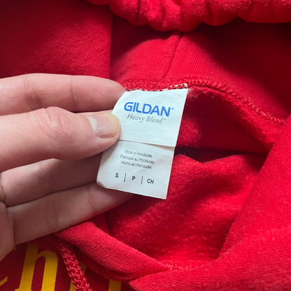 Bevar Christiania Red Hoodie is a red pullover hoodie made on a Gildan Heavy Blend blank, manufactured in Honduras. It features a classic construction with an adjustable hood and a front kangaroo pocket. The front displays yellow “Bevar Christiania” text with three large yellow dots printed underneath.