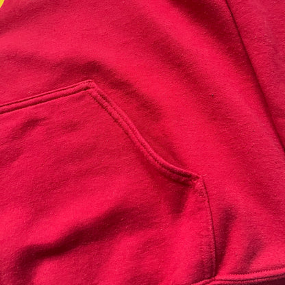 Bevar Christiania Red Hoodie is a red pullover hoodie made on a Gildan Heavy Blend blank, manufactured in Honduras. It features a classic construction with an adjustable hood and a front kangaroo pocket. The front displays yellow “Bevar Christiania” text with three large yellow dots printed underneath.