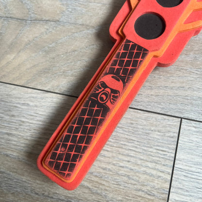 Bionicle 2003 Toa Tahu Flame Sword is a foam toy sword finished in red, orange, and black. The blade features a flame-shaped design at the top, while the handle has a standard grip construction. A small Bionicle mask is attached to the bottom of the handle. The sword is marked with Bionicle and LEGOLAND branding.