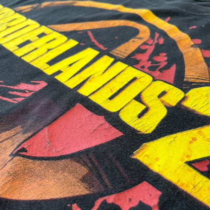 Borderlands 2 Promo 2010's Tee features a black boxy construction with a thick yellow and red Borderlands 2 logo printed on the front. A blood-splatter graphic appears behind the logo, and the shirt is made from 100% cotton.
