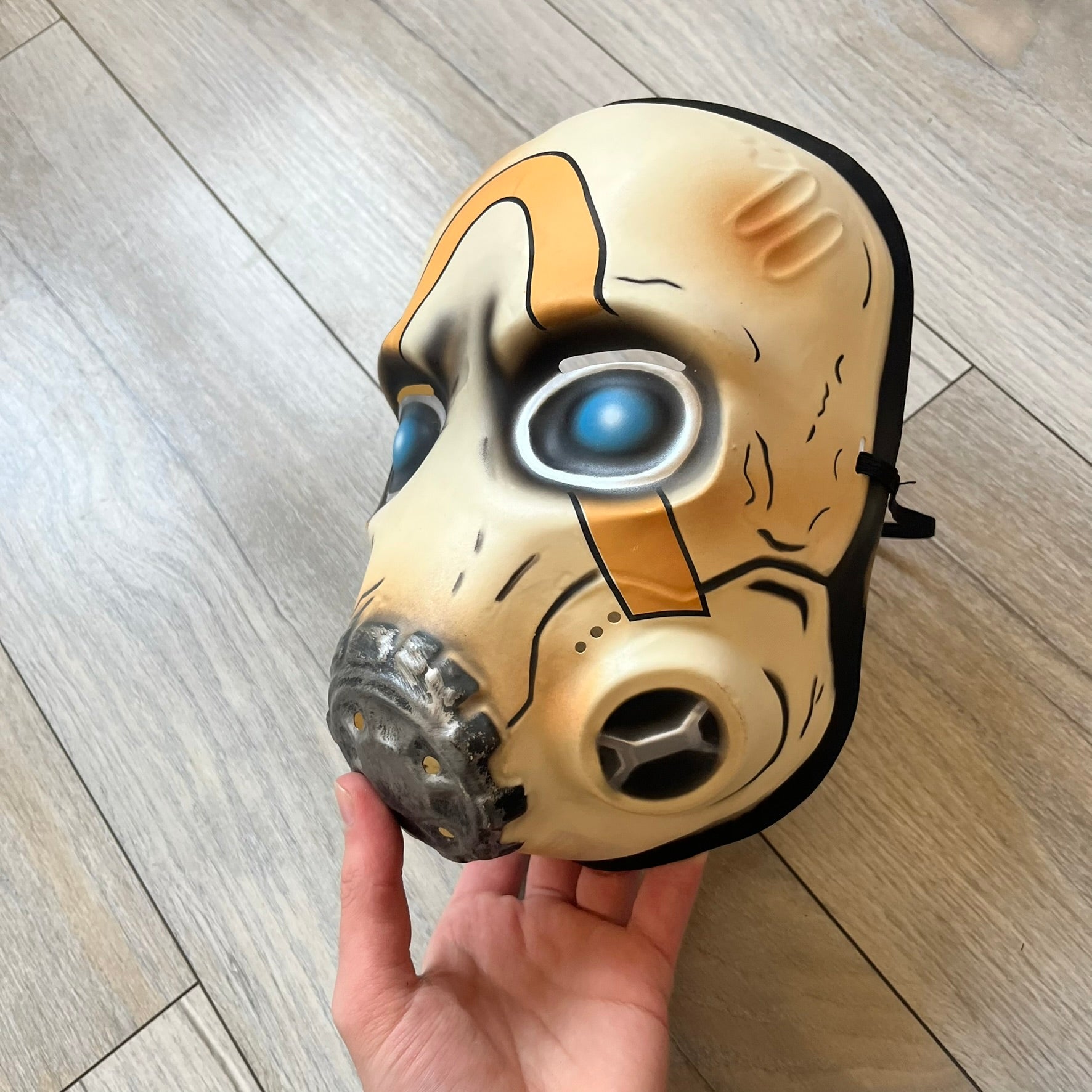 Borderlands 3 Pre-Order Exclusive Psycho Mask is a plastic character mask based on the Psycho enemy from the video game. The mask recreates the character’s white bandit mask design with detailed sculpting and includes an adjustable rubber strap for wearing. The interior features foam padding for a more secure fit on the head. Psychos are one of the most recognizable characters in the Borderlands franchise and appear as masked bandits throughout the series.