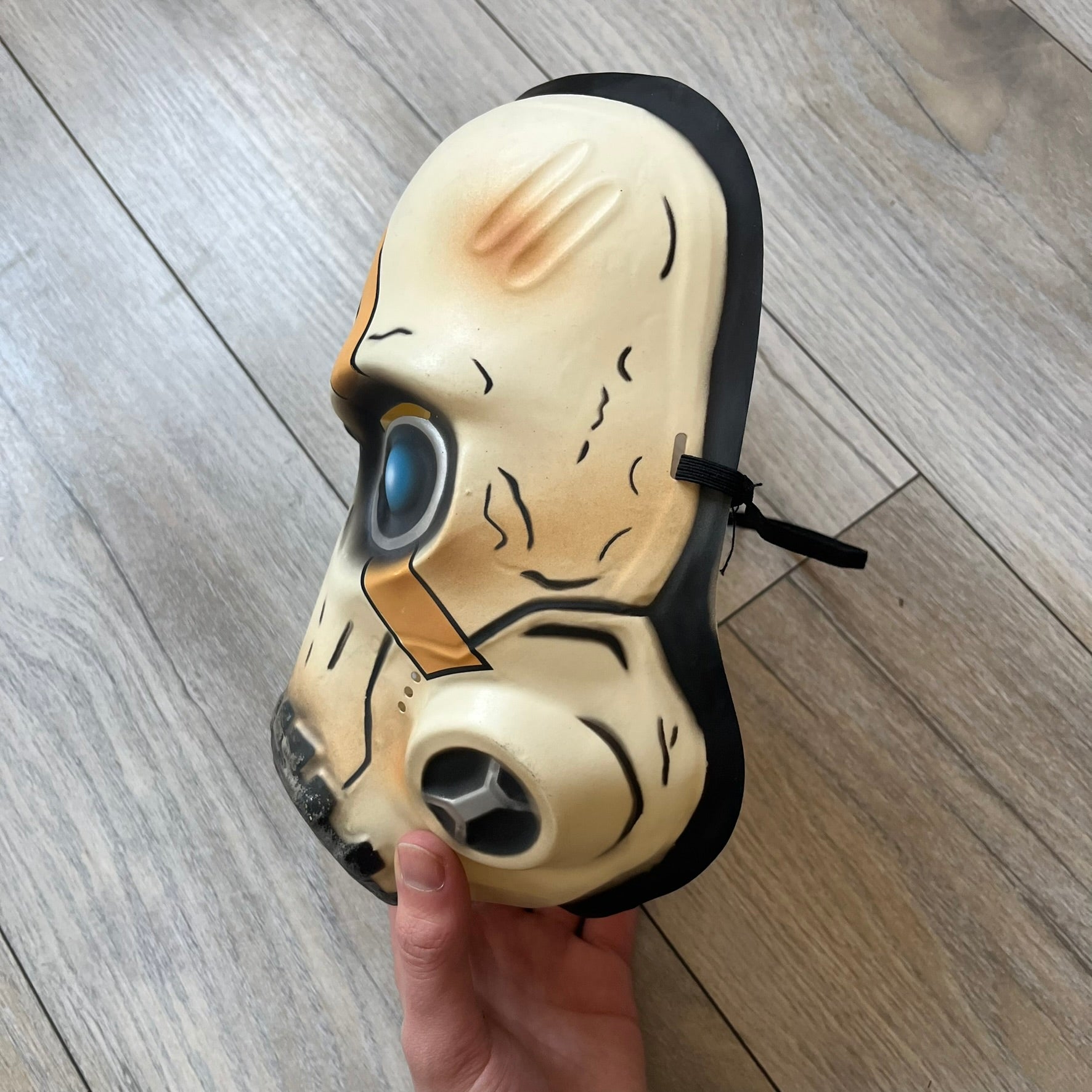 Borderlands 3 Pre-Order Exclusive Psycho Mask is a plastic character mask based on the Psycho enemy from the video game. The mask recreates the character’s white bandit mask design with detailed sculpting and includes an adjustable rubber strap for wearing. The interior features foam padding for a more secure fit on the head. Psychos are one of the most recognizable characters in the Borderlands franchise and appear as masked bandits throughout the series.