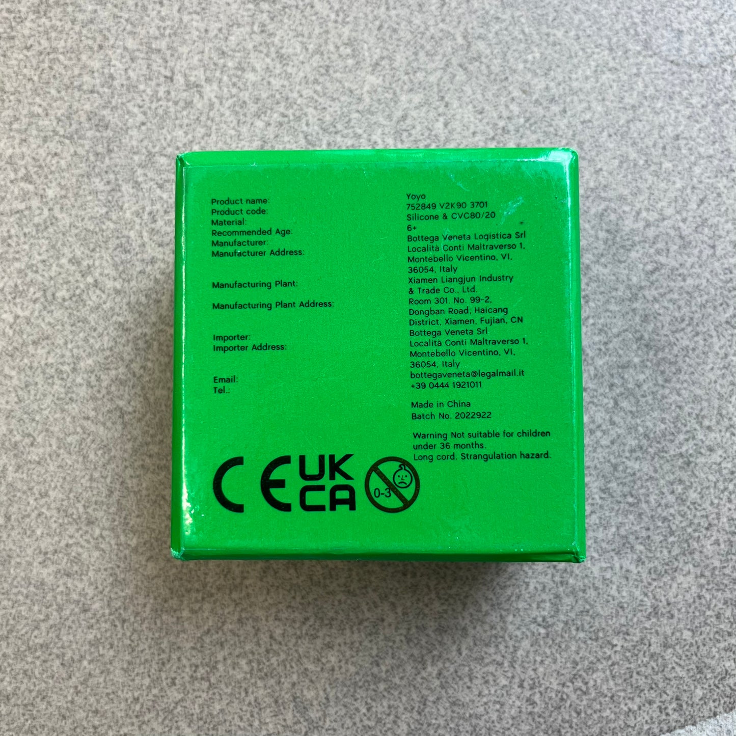 Bottega Veneta Green Rubber Yo-Yo is a collectible accessory crafted from green and black silicone. It features green outer halves with a black center section, a black string, and an engraved Bottega Veneta logo on one side. The yo-yo comes complete with its original box and paper bag.
