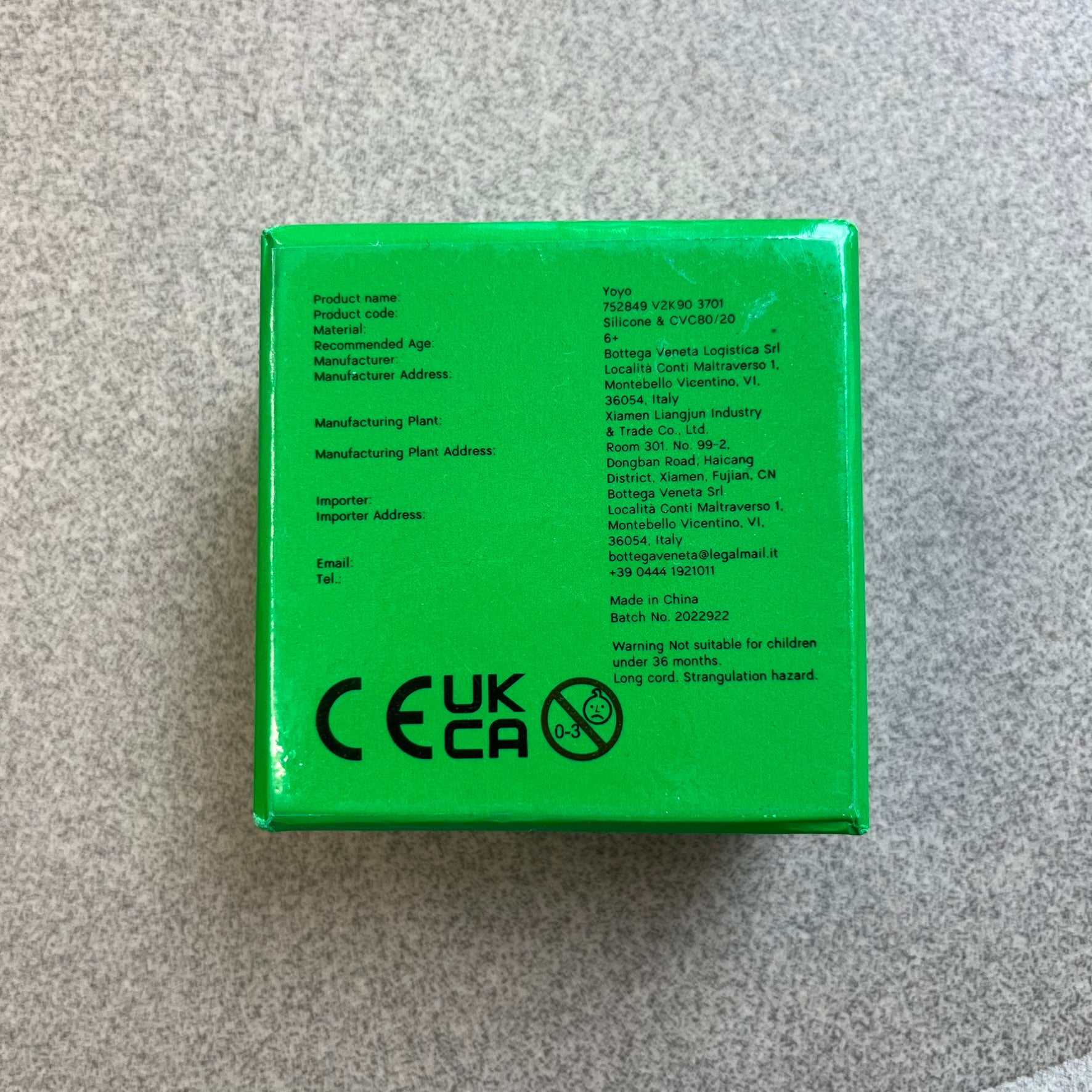 Bottega Veneta Green Rubber Yo-Yo is a collectible accessory crafted from green and black silicone. It features green outer halves with a black center section, a black string, and an engraved Bottega Veneta logo on one side. The yo-yo comes complete with its original box and paper bag.
