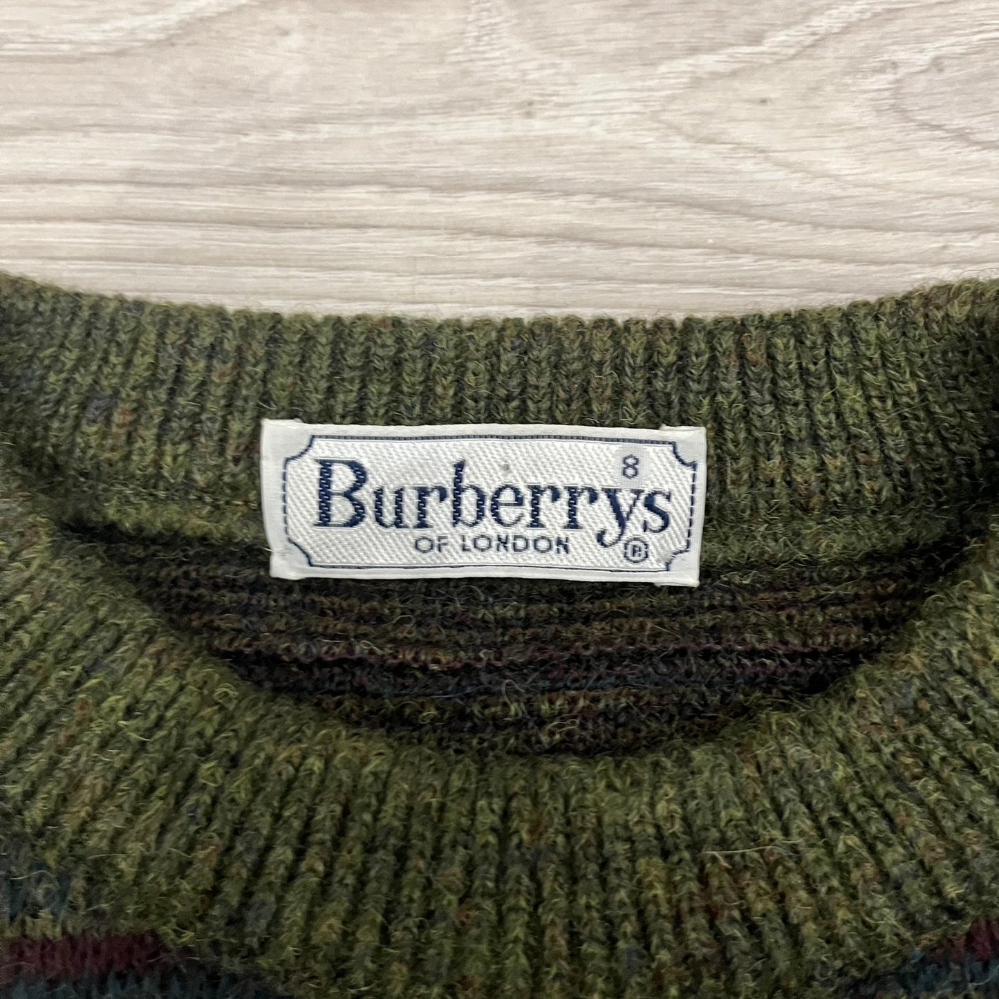 Burberry’s of London 90’s Sweater from 1998/99, crafted from a blend of acrylic, mohair, polyamide, wool, alpaca, and viscose. Features an all-over repeat pattern in green, navy, and brown tones. Vintage piece with original white Burberry tag.