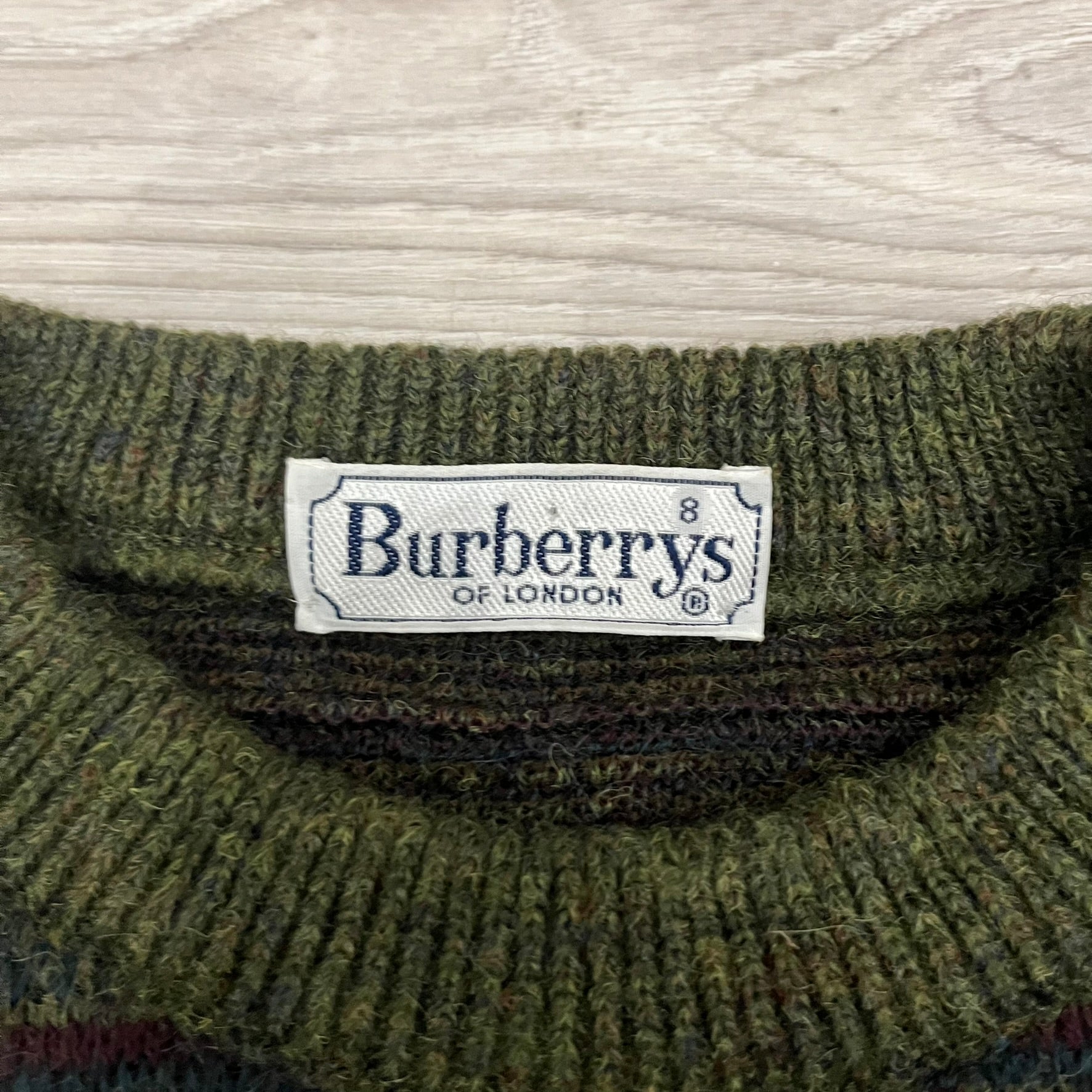 Burberry’s of London 90’s Sweater from 1998/99, crafted from a blend of acrylic, mohair, polyamide, wool, alpaca, and viscose. Features an all-over repeat pattern in green, navy, and brown tones. Vintage piece with original white Burberry tag.