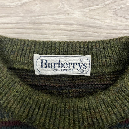 Burberry’s of London 90’s Sweater from 1998/99, crafted from a blend of acrylic, mohair, polyamide, wool, alpaca, and viscose. Features an all-over repeat pattern in green, navy, and brown tones. Vintage piece with original white Burberry tag.