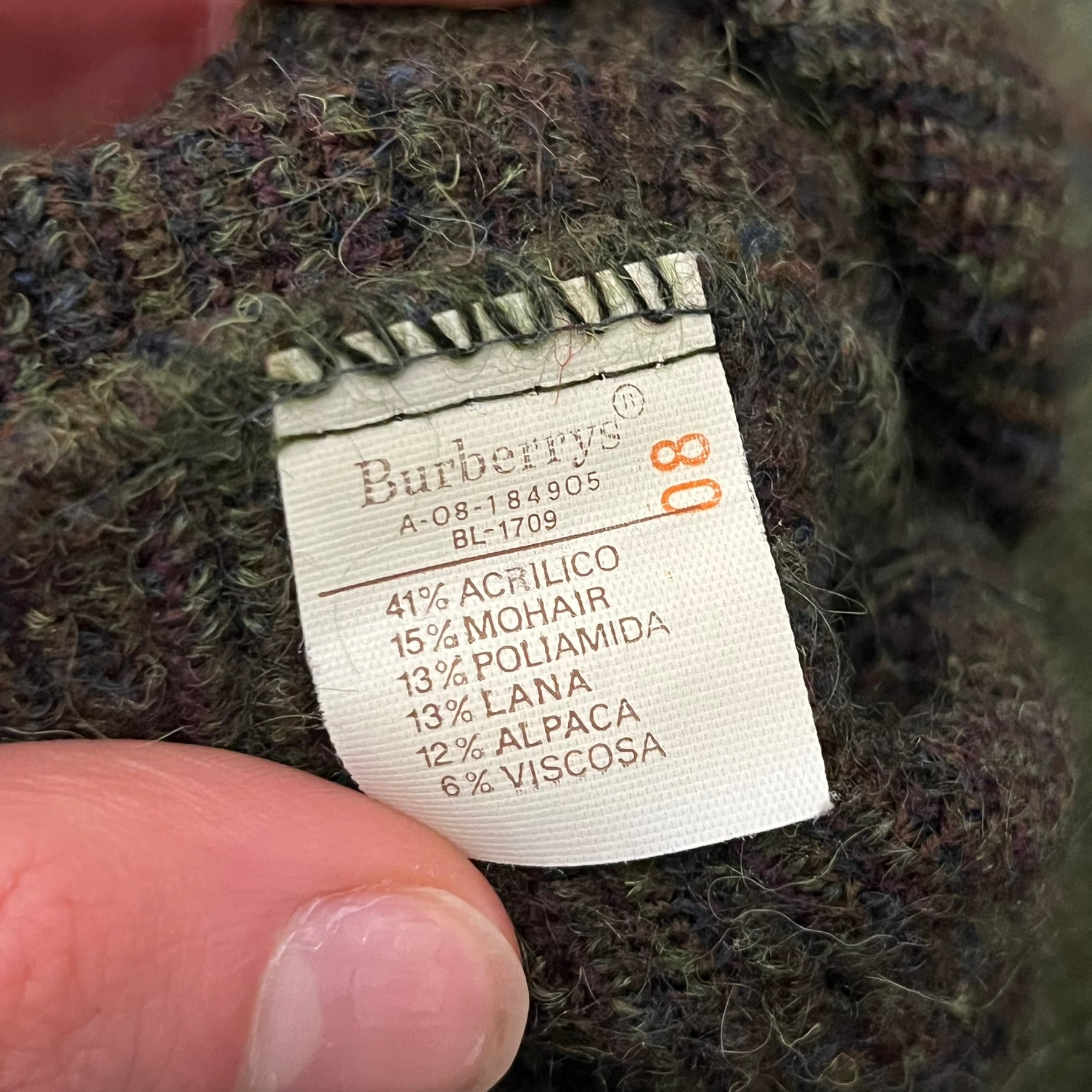 Burberry’s of London 90’s Sweater from 1998/99, crafted from a blend of acrylic, mohair, polyamide, wool, alpaca, and viscose. Features an all-over repeat pattern in green, navy, and brown tones. Vintage piece with original white Burberry tag.