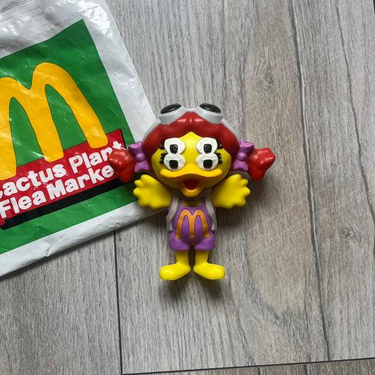 CPFM x McDonald's Birdie The Early Bird Figure from the 2022 collaboration between Cactus Plant Flea Market and McDonald’s. Features the signature yellow Bird character wearing a pruple and orange McDonald’s overalls ,with CPFM’s iconic four-eye design. Released as part of the adult Happy Meal collection in FW22, licensed on the back. Comes with the Foil bag.
