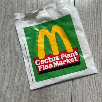 CPFM x McDonald's Birdie The Early Bird Figure from the 2022 collaboration between Cactus Plant Flea Market and McDonald’s. Features the signature yellow Bird character wearing a pruple and orange McDonald’s overalls ,with CPFM’s iconic four-eye design. Released as part of the adult Happy Meal collection in FW22, licensed on the back. Comes with the Foil bag.