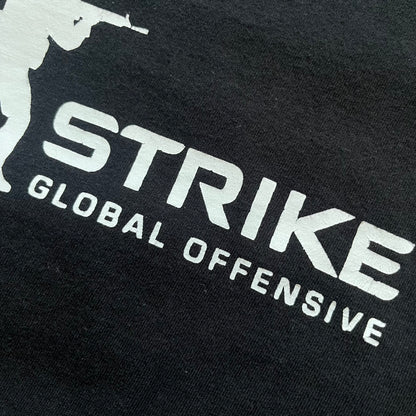 CS:GO Black &amp; White Logo 2010's Tee is a black T-shirt made on a JHK blank. The front features a large white CS:GO logo with an armed figure&nbsp; and “Counter-Strike Global Offensive” text below. Super simple - classic CS logo.