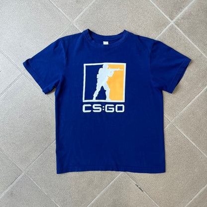 CS:GO Logo Navy Tee features a navy blue design with a large Counter-Strike: Global Offensive logo printed across the front. The graphic showcases the iconic navy, orange, and white CS:GO logo with the Counter-Terrorists silhouette above big white "CS:GO" text. Made from 100% cotton.