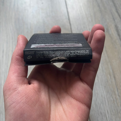 Original physical Counter-Strike: Global Offensive Series 1 Guardian pin, produced as official Valve merchandise. These pins were sold at Valve-sponsored CS:GO Major events and later through the official WeLoveFine store, and originally included a code to unlock a “Genuine” in-game digital pin on a Steam profile. This example comes complete with the original packaging; the code has been scratched and is already used.