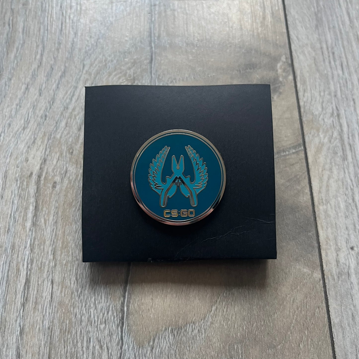 Original physical Counter-Strike: Global Offensive Series 1 Guardian pin, produced as official Valve merchandise. These pins were sold at Valve-sponsored CS:GO Major events and later through the official WeLoveFine store, and originally included a code to unlock a “Genuine” in-game digital pin on a Steam profile. This example comes complete with the original packaging; the code has been scratched and is already used.