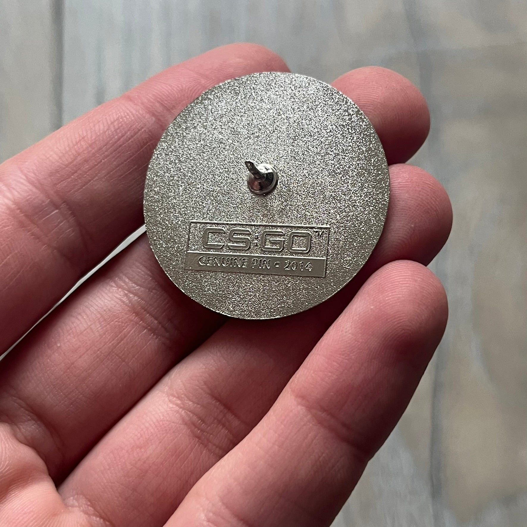 Original physical Counter-Strike: Global Offensive Series 1 Nuke pin, produced as official Valve merchandise. These pins were sold at Valve-sponsored CS:GO Major events and later via the official WeLoveFine store, and originally included a code to unlock a “Genuine” Nuke pin for the user’s Steam profile. This example comes with the original packaging; the code has been scratched (by me) but remains unused.