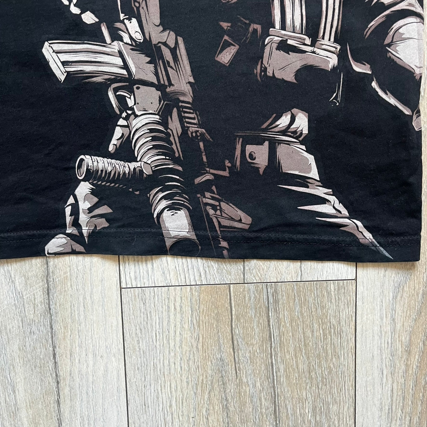 Call of Duty: Black Ops 2018 Black Tee is a black promotional T-shirt with a 2018 Activision Publishing licensed neck tag. The front features a large white and grey character graphic in armor holding a weapon, with the “Call of Duty Black Ops” logo printed above. The print spans most of the front from top to bottom.
