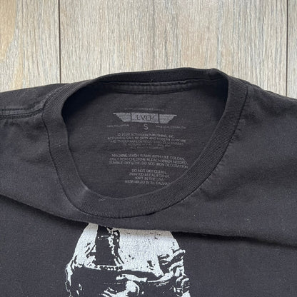 Call of Duty: Modern Warfare 2 2009 Tee is a black T-shirt featuring a large white detailed character print from the game with green “MW2” text below. The sleeve includes an Infinity Ward logo, and the neck tag shows 2009 Activision LVLP branding. Official merchandise from the 2009 Modern Warfare 2 release.