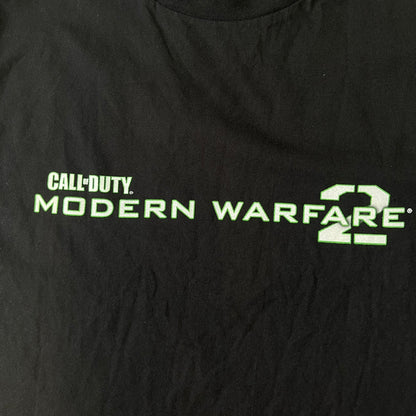 Call of Duty: Modern Warfare 2 2010s Tee features a simple design with the Call of Duty: Modern Warfare 2 logo printed on the front in white and green. The sleeve includes an Infinity Ward logo detail, while the neck has a basic size tag. A later 2010s release inspired by the iconic Modern Warfare 2 branding, not the original promotional tee.
