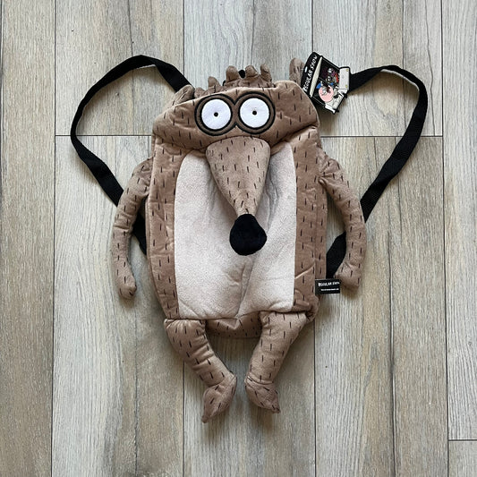Cartoon Network Regular Show Rigby 2016 Backpack is a character-shaped backpack designed as Rigby from the animated series Regular Show. The bag features a full plush body construction with movable arms, legs, and mouth, while the eyes and mouth are finished with embroidered detailing. Adjustable straps are attached from the top to the lower back of the character, allowing it to be worn as a standard backpack. The design follows Rigby’s appearance with brown fur tones, dark raccoon-style eye mask markings, 