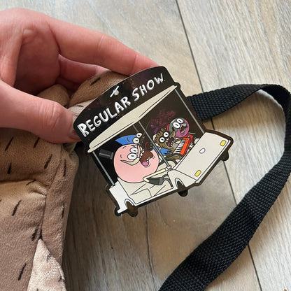 Cartoon Network Regular Show Rigby 2016 Backpack is a character-shaped backpack designed as Rigby from the animated series Regular Show. The bag features a full plush body construction with movable arms, legs, and mouth, while the eyes and mouth are finished with embroidered detailing. Adjustable straps are attached from the top to the lower back of the character, allowing it to be worn as a standard backpack. The design follows Rigby’s appearance with brown fur tones, dark raccoon-style eye mask markings, 