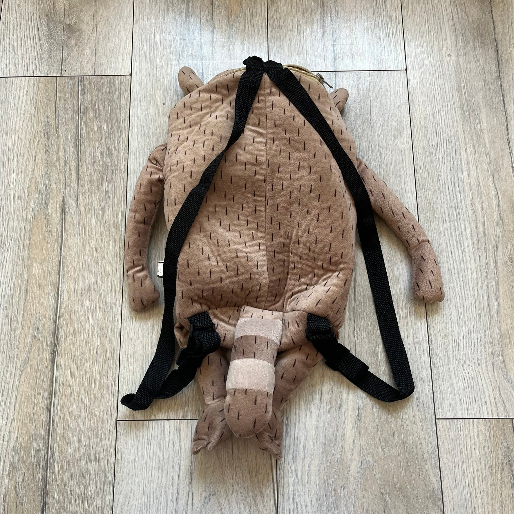 Cartoon Network Regular Show Rigby 2016 Backpack is a character-shaped backpack designed as Rigby from the animated series Regular Show. The bag features a full plush body construction with movable arms, legs, and mouth, while the eyes and mouth are finished with embroidered detailing. Adjustable straps are attached from the top to the lower back of the character, allowing it to be worn as a standard backpack. The design follows Rigby’s appearance with brown fur tones, dark raccoon-style eye mask markings, 