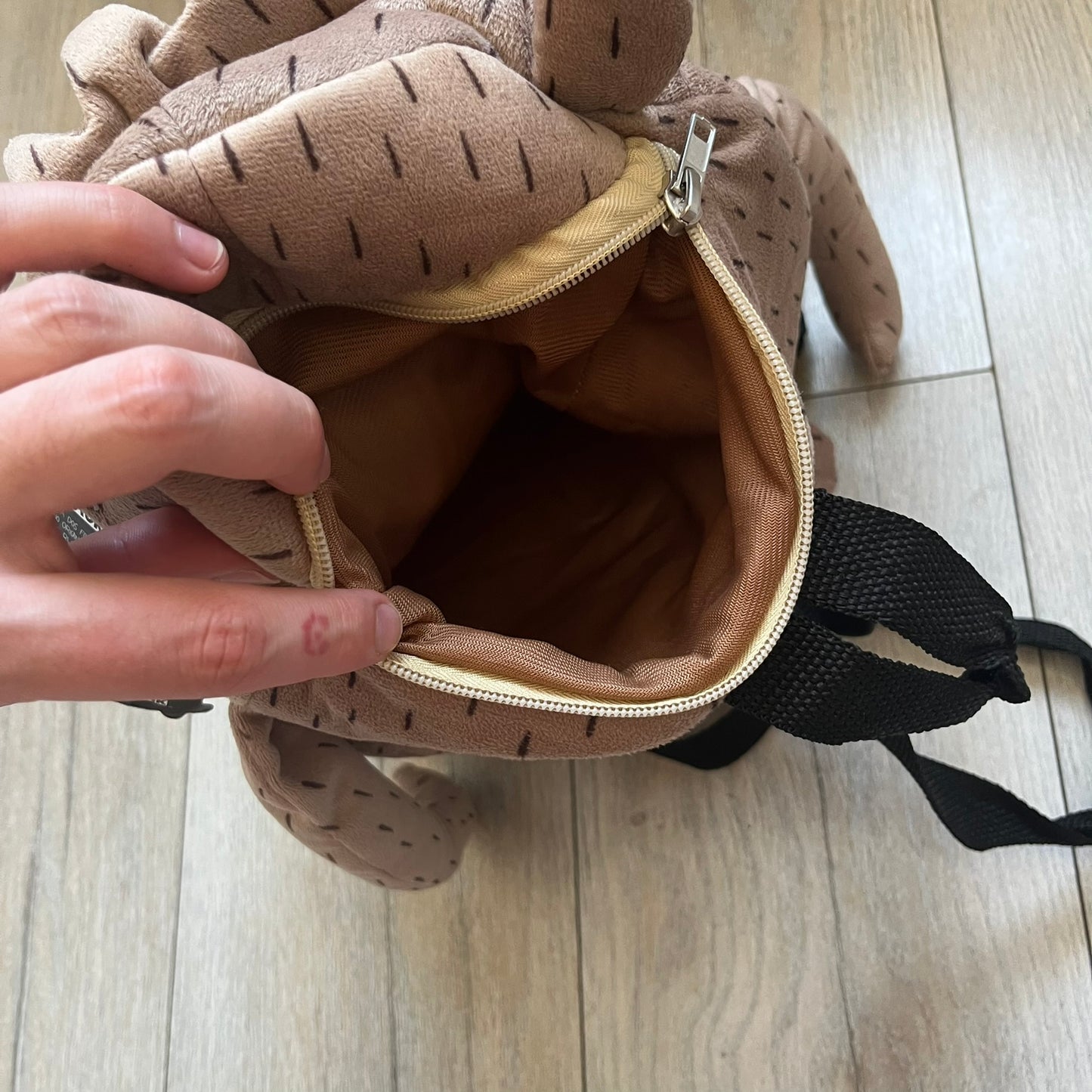 Cartoon Network Regular Show Rigby 2016 Backpack is a character-shaped backpack designed as Rigby from the animated series Regular Show. The bag features a full plush body construction with movable arms, legs, and mouth, while the eyes and mouth are finished with embroidered detailing. Adjustable straps are attached from the top to the lower back of the character, allowing it to be worn as a standard backpack. The design follows Rigby’s appearance with brown fur tones, dark raccoon-style eye mask markings, 